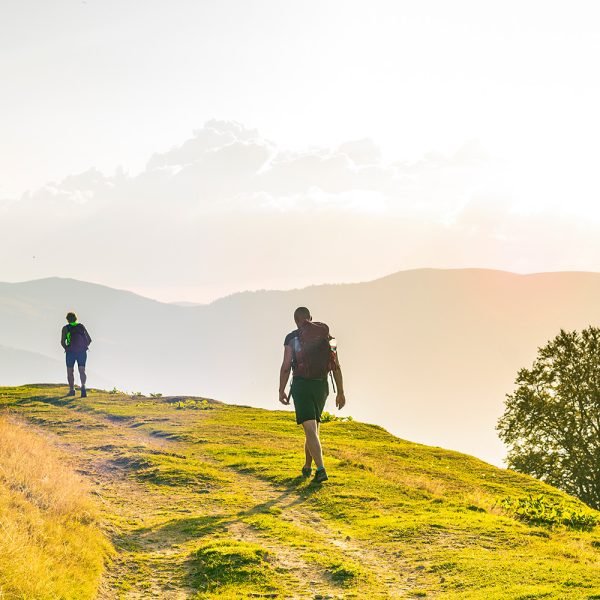 A man and a woman are walking along a tourist route high in the